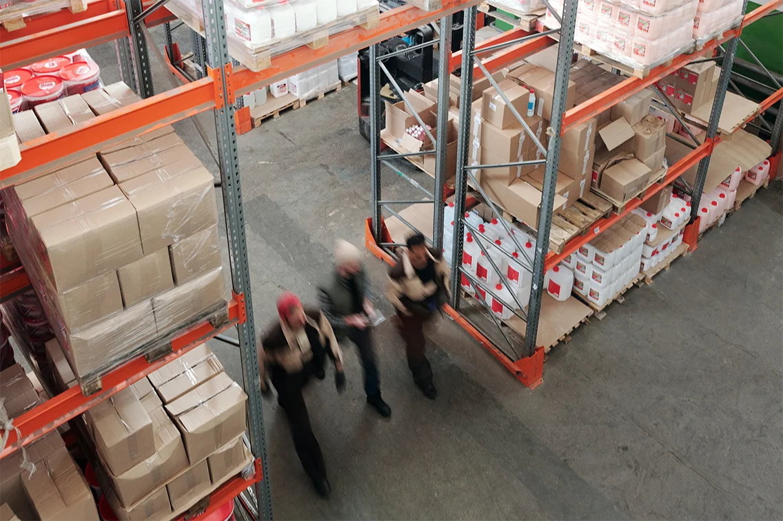 Warehouse workers with executives in warehouse